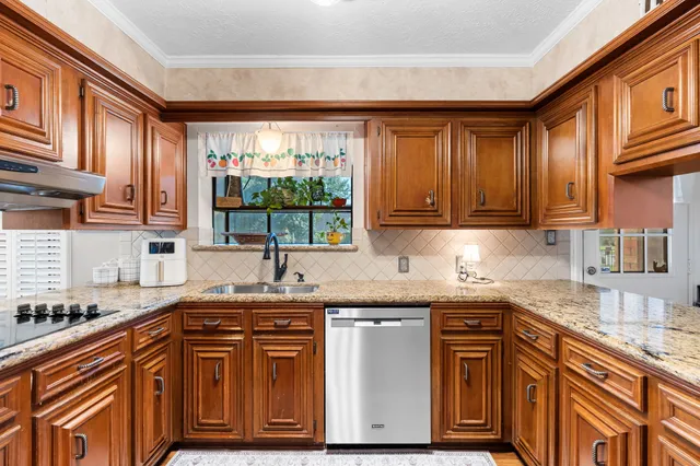 a kitchen with stainless steel appliances granite countertop wooden cabinets a sink and dishwasher
