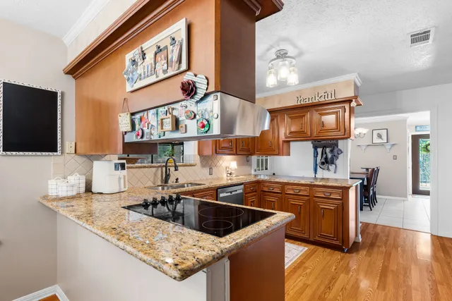 a kitchen with stainless steel appliances granite countertop a sink stove and cabinets