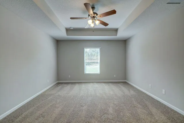 an empty room with a window and a fan