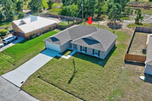 an aerial view of a house with swimming pool garden and patio