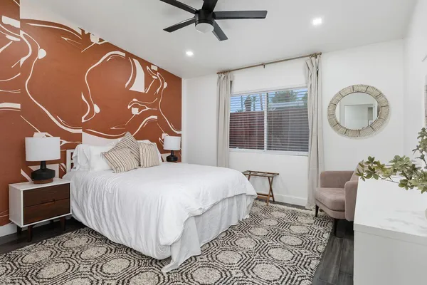 a bedroom with a bed and dresser with mirror