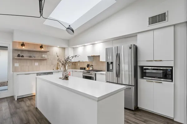 a kitchen with a sink a refrigerator and cabinets