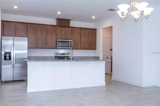 a kitchen with kitchen island granite countertop cabinets and refrigerator