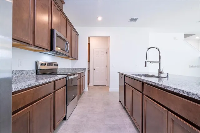 a kitchen with granite countertop stainless steel appliances and sink