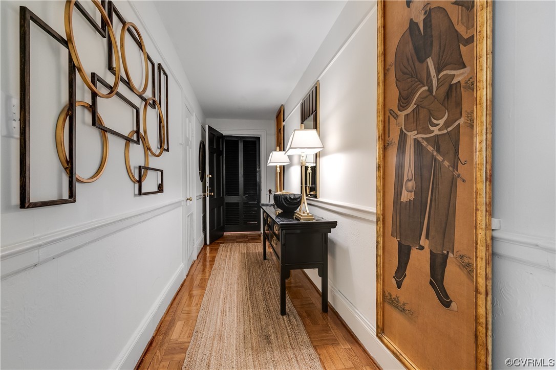 5621 Cary Street Road, Unit U206 Richmond, VA 23226 - Photo 6 of 34 a hallway with a white stove top oven a rug and a wooden floor