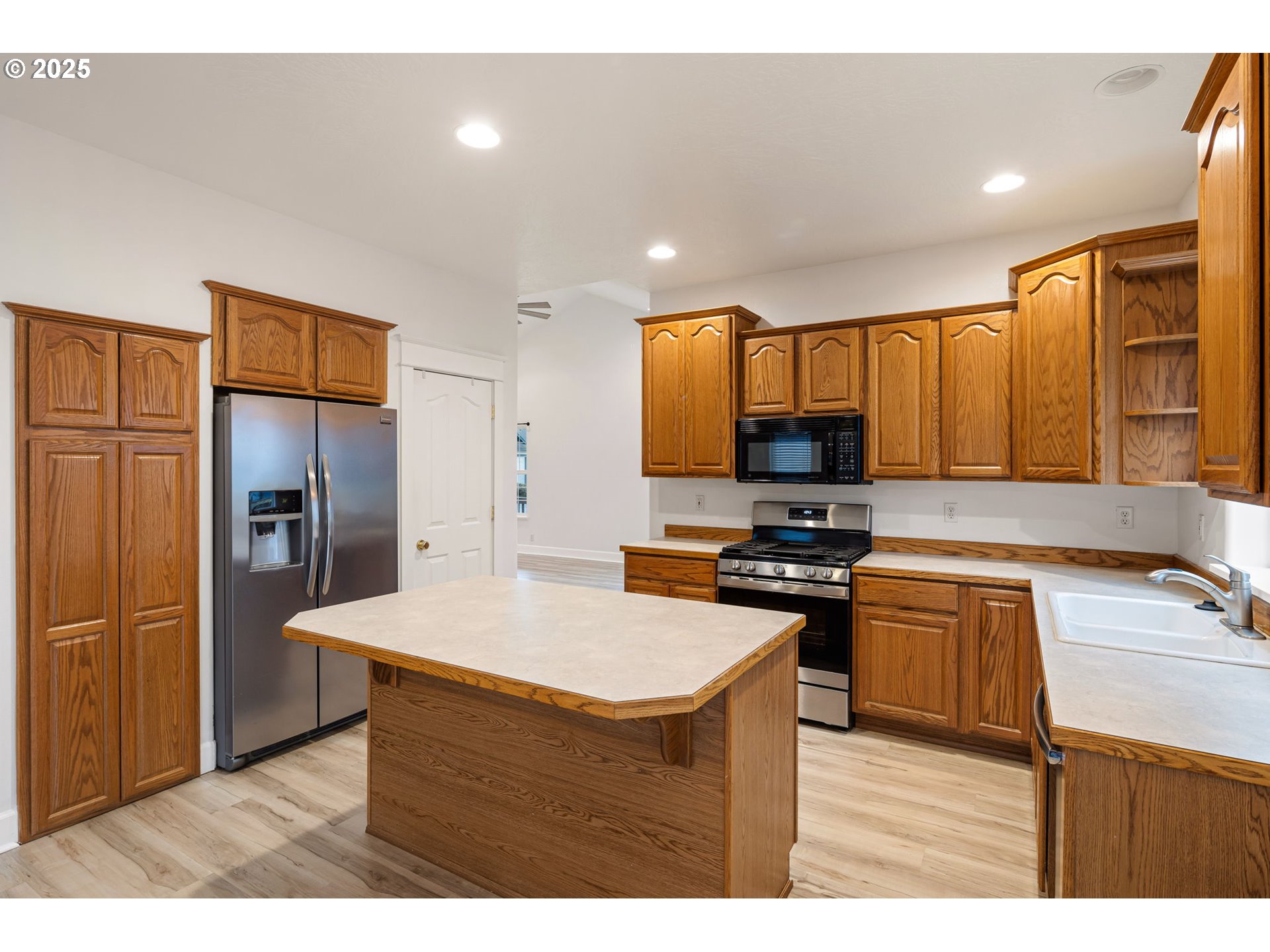 6808 Moses Pass Springfield, OR 97478 - Photo 11 of 37 a kitchen with stainless steel appliances granite countertop a refrigerator a sink dishwasher a stove with wooden cabinets and floors