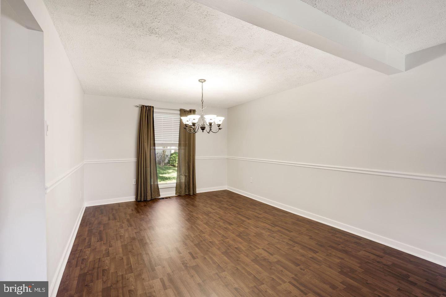 6372 Shadowshape Place Columbia, MD 21045 - Photo 8 of 36 an empty room with wooden floor mirror and windows