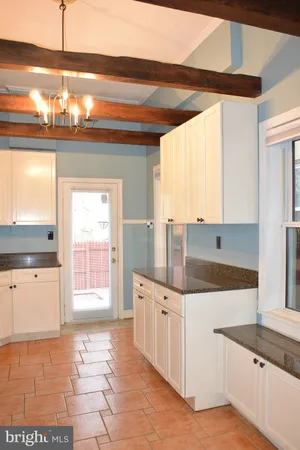 a kitchen with granite countertop a sink a stove and cabinets