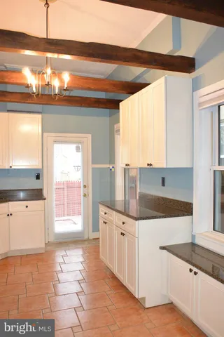 a kitchen with granite countertop a sink a stove and cabinets
