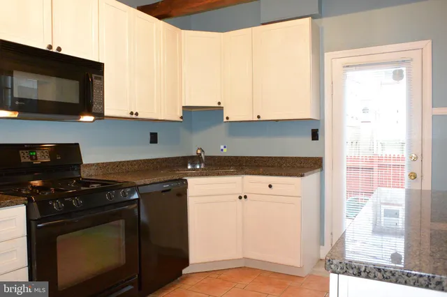 a kitchen with stainless steel appliances granite countertop a stove a microwave and a refrigerator