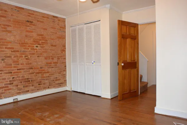 an empty room with wooden floor and closet