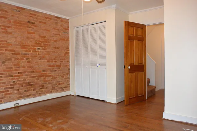 an empty room with wooden floor and closet