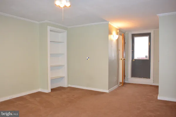 a view of an empty room and chandelier fan