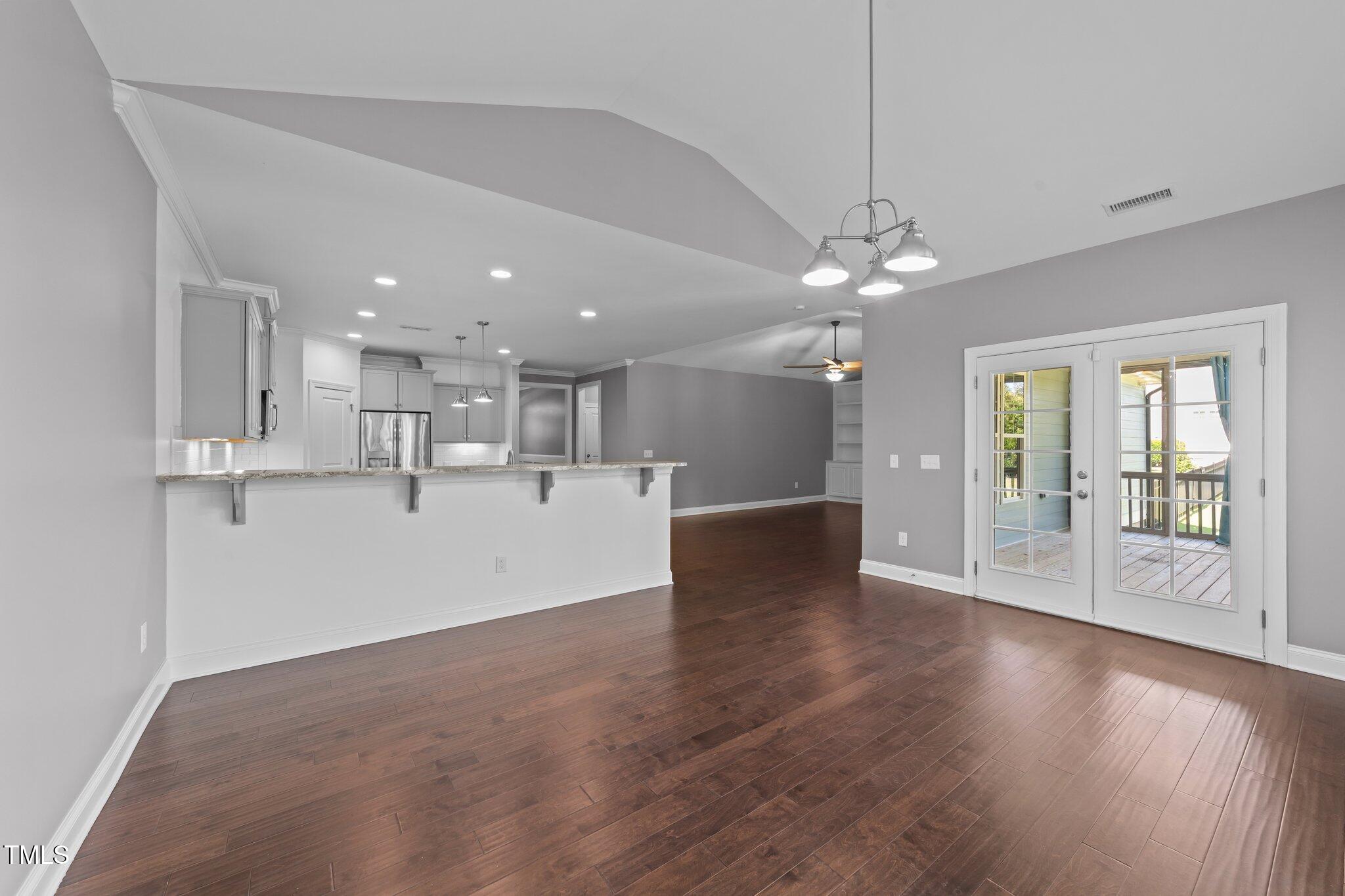 4125 Olde Judd Drive Willow Spring, NC 27592 - Photo 17 of 48 a view of an empty room with wooden floor and a kitchen