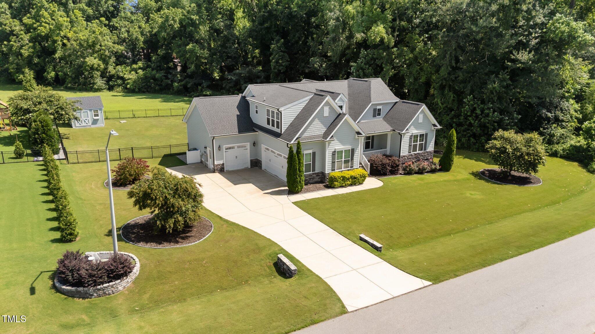 4125 Olde Judd Drive Willow Spring, NC 27592 - Photo 42 of 48 a view of a white house with a big yard and large trees
