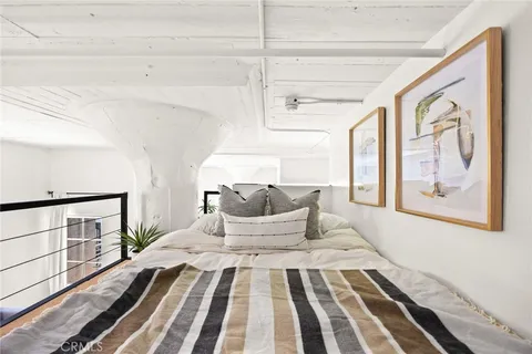 a bedroom with a large bed and wooden floor