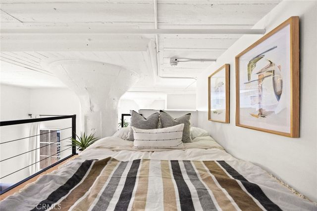 a bedroom with a large bed and wooden floor