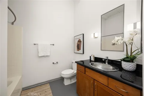 a bathroom with a granite countertop sink a toilet and mirror