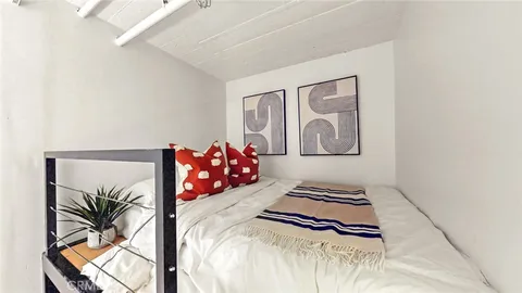 a bedroom with a bed and a painting on the wall