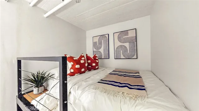 a bedroom with a bed and a painting on the wall