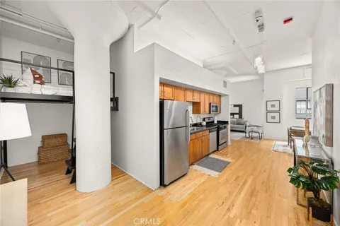 a kitchen with stainless steel appliances a refrigerator and wooden floor