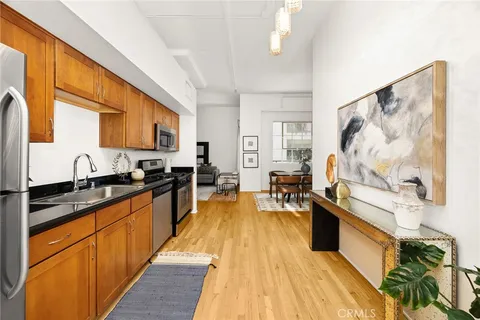 a large kitchen with stainless steel appliances granite countertop a stove a sink dishwasher and cabinets with wooden floor