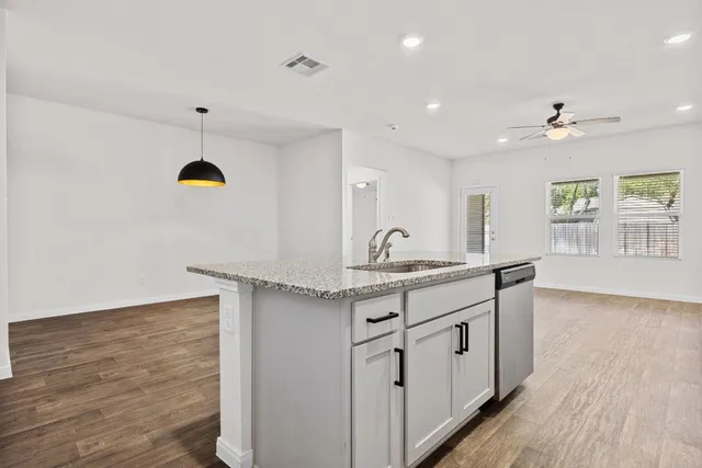 a kitchen with granite countertop a stove a sink and a refrigerator