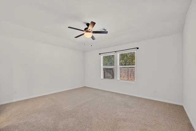 a view of empty room with a ceiling fan and wooden floor