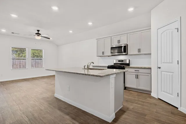 a kitchen with stainless steel appliances granite countertop a stove and a refrigerator