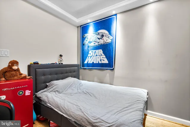 a bedroom with a bed and painting on the wall