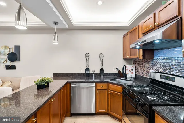 a kitchen with stainless steel appliances granite countertop a sink stove and cabinets