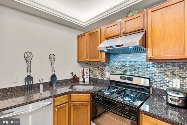 a kitchen with granite countertop a stove a sink and a granite counter tops