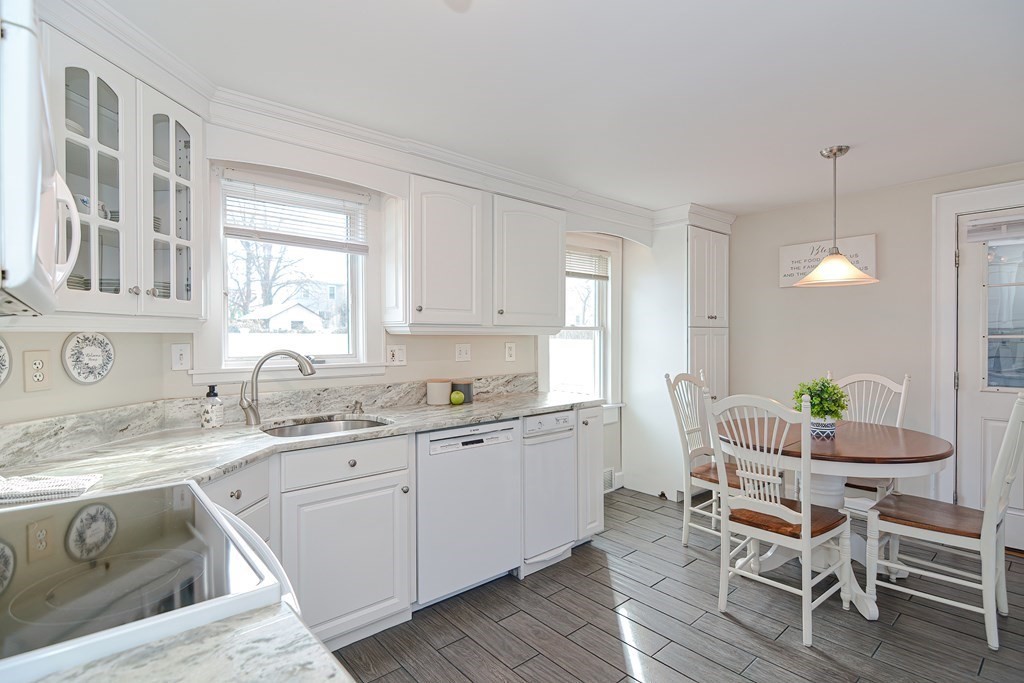 a kitchen with a sink white cabinets and wooden floor