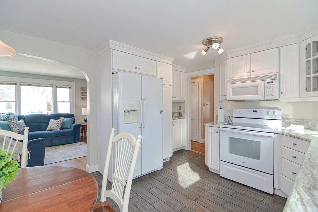 35 Colasanti Road Weymouth, MA 02191 - Photo 12 of 39 a kitchen with stainless steel appliances a stove a sink dishwasher a refrigerator and white cabinets with wooden floor