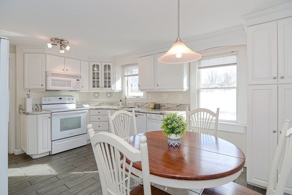 35 Colasanti Road Weymouth, MA 02191 - Photo 10 of 39 a kitchen with white cabinets stainless steel appliances and a table