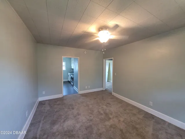 an empty room with a fireplace and windows