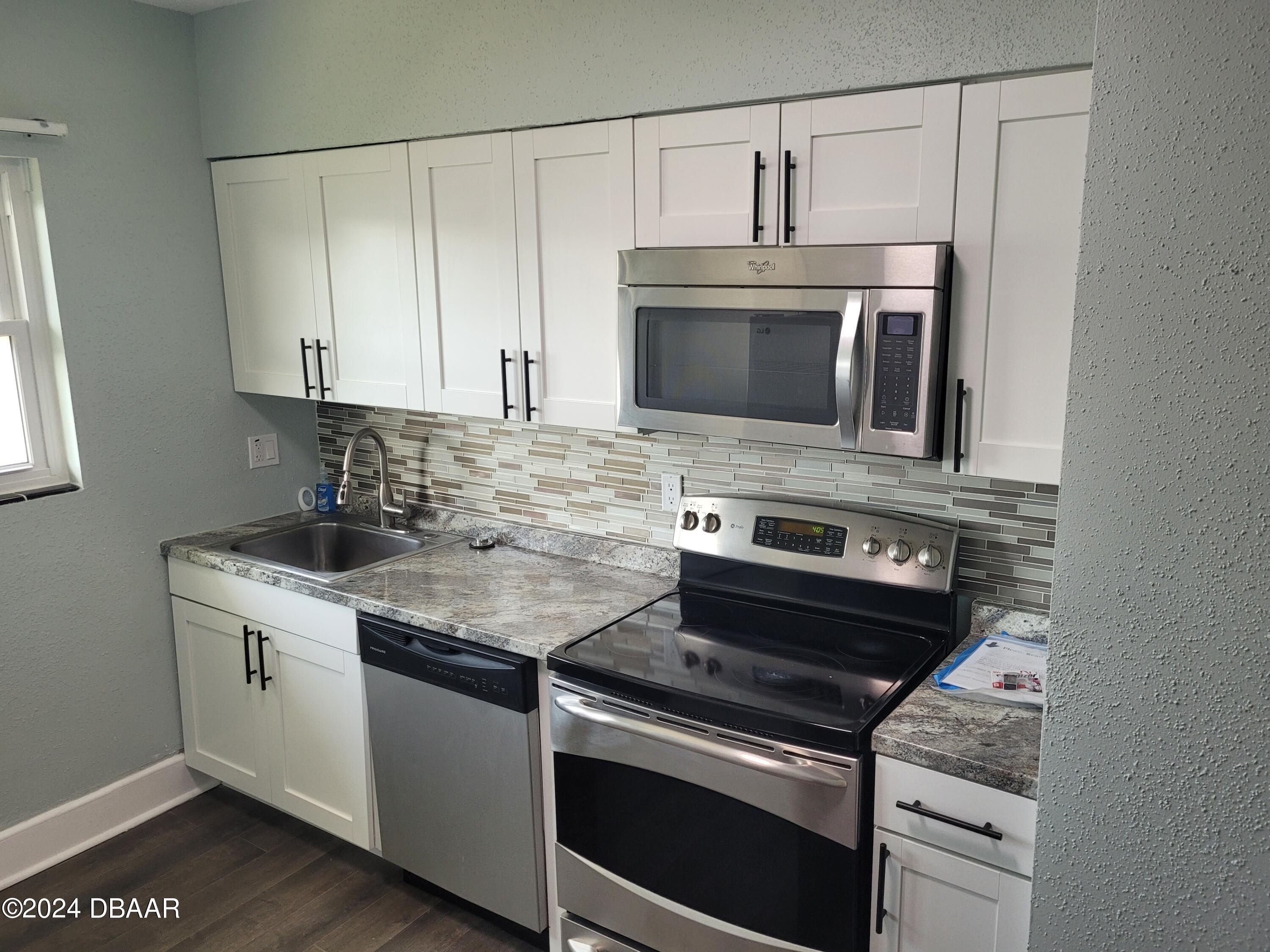 500 South Beach Street, Unit J4 Daytona Beach, FL 32114 - Photo 15 of 36 a kitchen with cabinets stainless steel appliances and sink