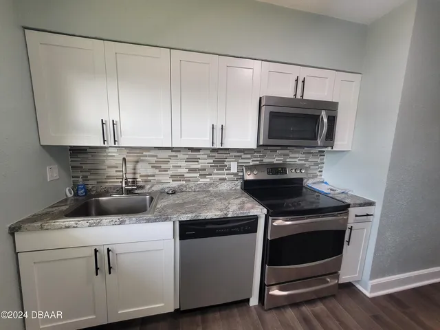 a kitchen with a sink a stove and cabinets