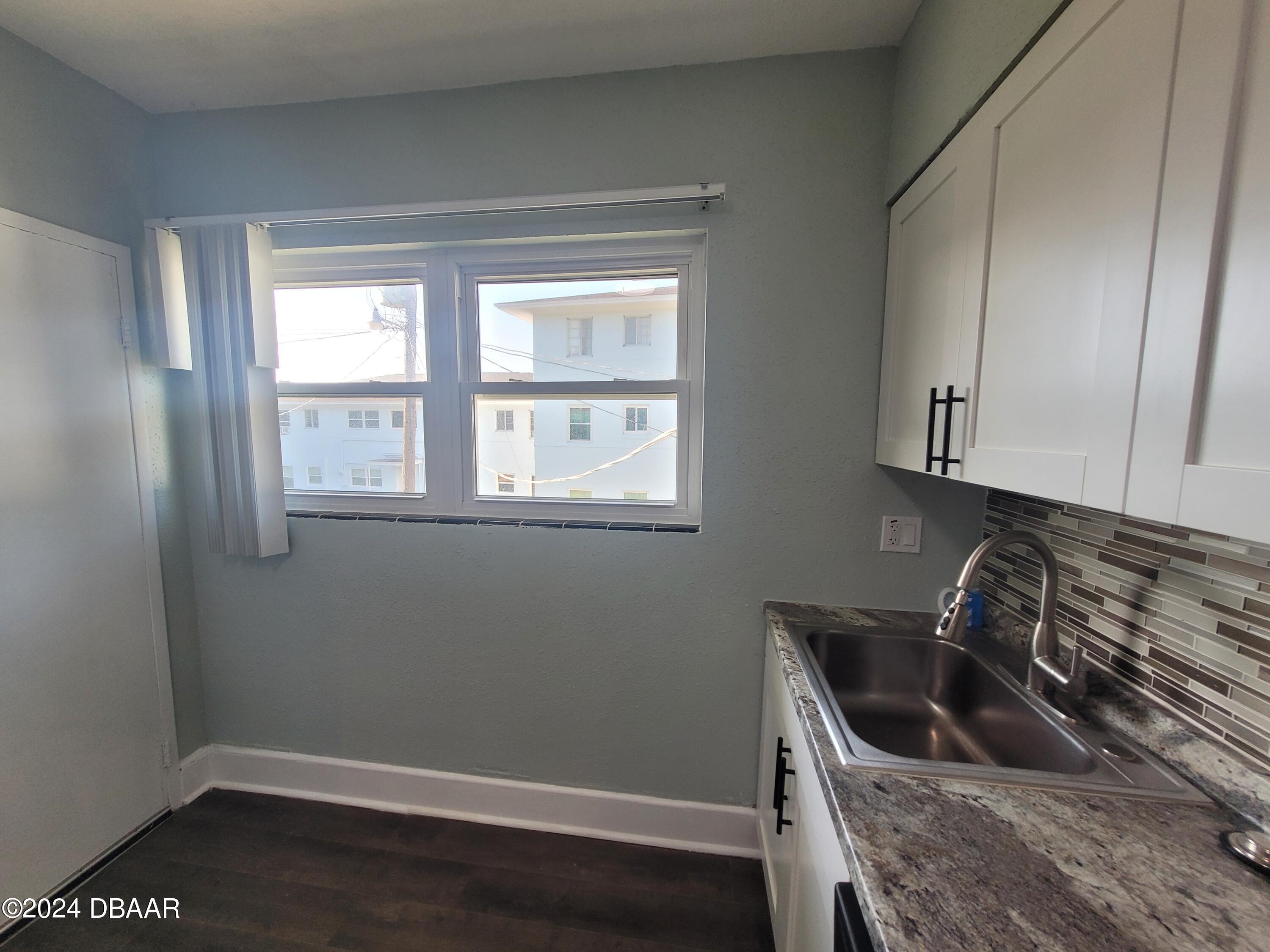 500 South Beach Street, Unit J4 Daytona Beach, FL 32114 - Photo 17 of 36 a kitchen with a sink a stove and cabinets