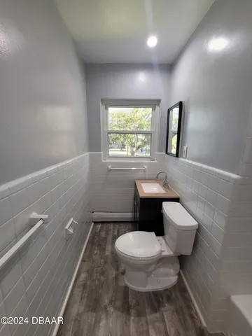 a white toilet sitting next to a bathroom sink and tub