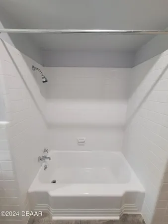 a view of a swimming pool with lawn chairs under an umbrella