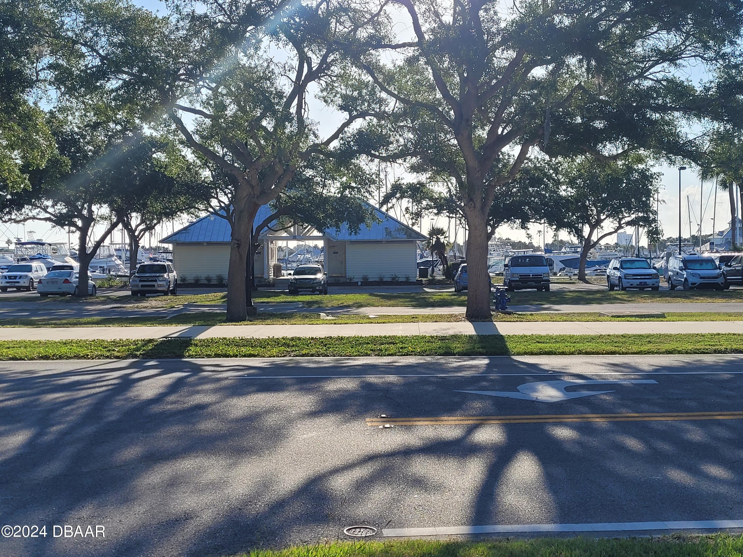 500 South Beach Street, Unit J4 Daytona Beach, FL 32114 - Photo 3 of 36 a view of a swimming pool with a yard and palm trees