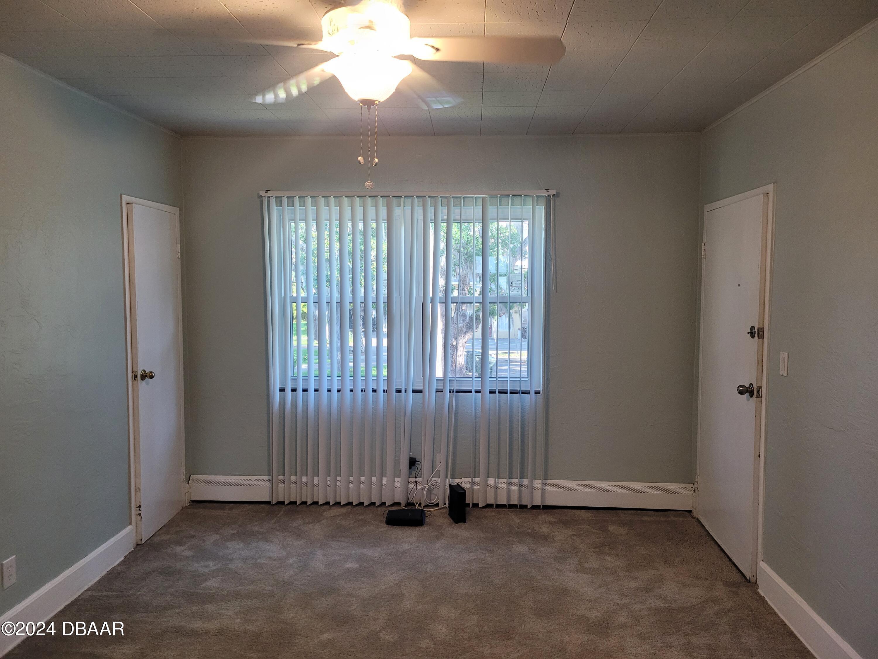 500 South Beach Street, Unit J4 Daytona Beach, FL 32114 - Photo 9 of 36 an empty room with wooden floor and windows