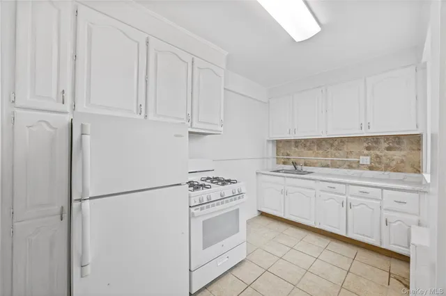 a kitchen with white cabinets and white appliances
