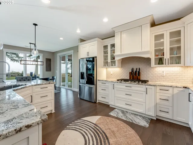 a large kitchen with granite countertop a large counter top appliances and cabinets