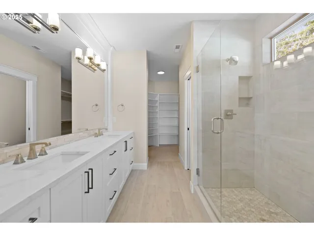 a bathroom with a double vanity sink mirror and shower