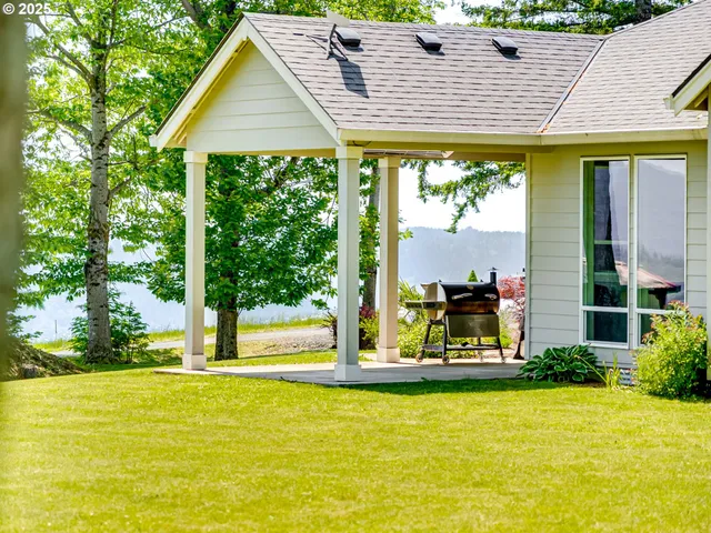 a view of a house with floor to ceiling windows and wooden fence