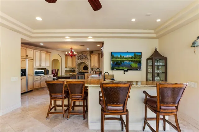 a dining hall with stainless steel appliances a dining table and chairs with a large window