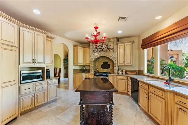 a kitchen with granite countertop a stove sink and cabinets