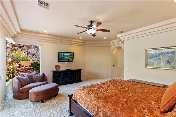 a living room with furniture a flat screen tv and floor to ceiling window